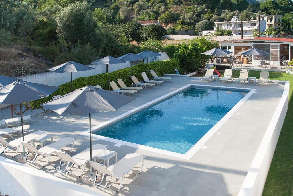an overhead view of a swimming pool with chairs and umbrellas at Dream House in Agia Paraskevi