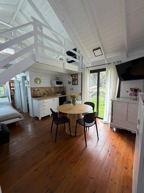 a kitchen and dining room with a table and chairs at בקתות עץ סקנדינביות במטולה in Metulla