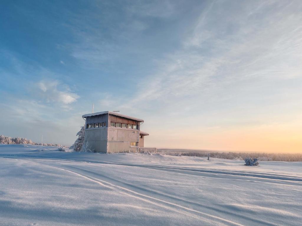 a building sitting on top of a snow covered field at Lumikko Aurora Loft in Enontekiö