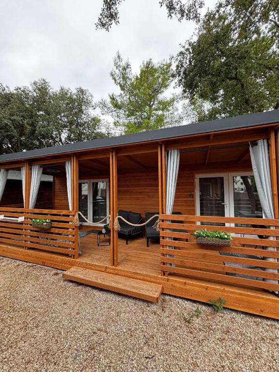 a wooden cabin with a large deck with windows at Moon apartments in Pakoštane