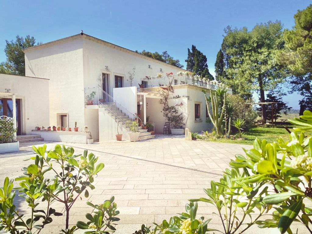 a large white house with a lot of plants at La Dimora di Ulisse in Santa Cesarea Terme