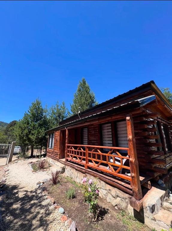 a log cabin with a wooden fence around it at cabañas de montaña Triskel in Aluminé