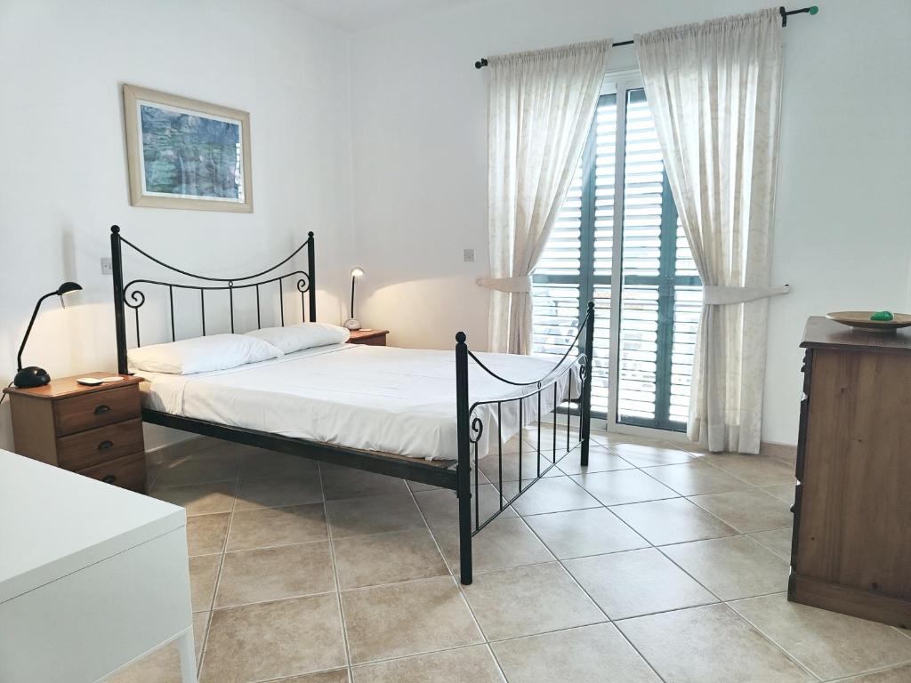 a bedroom with a bed and a large window at Sunset View in Polis Chrysochous