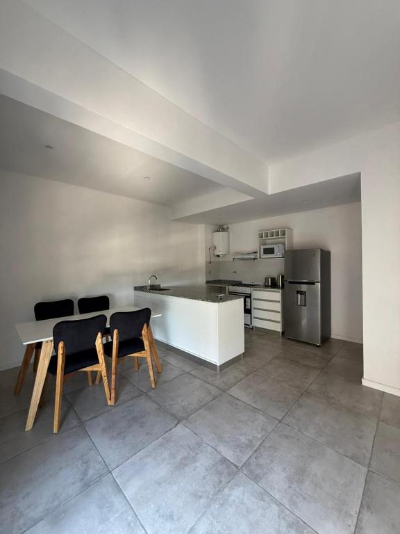 a kitchen with a table and chairs in a room at Altostay in Villa Constitución