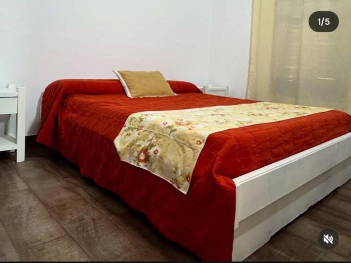 a bedroom with a bed with a red comforter at Paraíso Yapeyu in Yapeyú