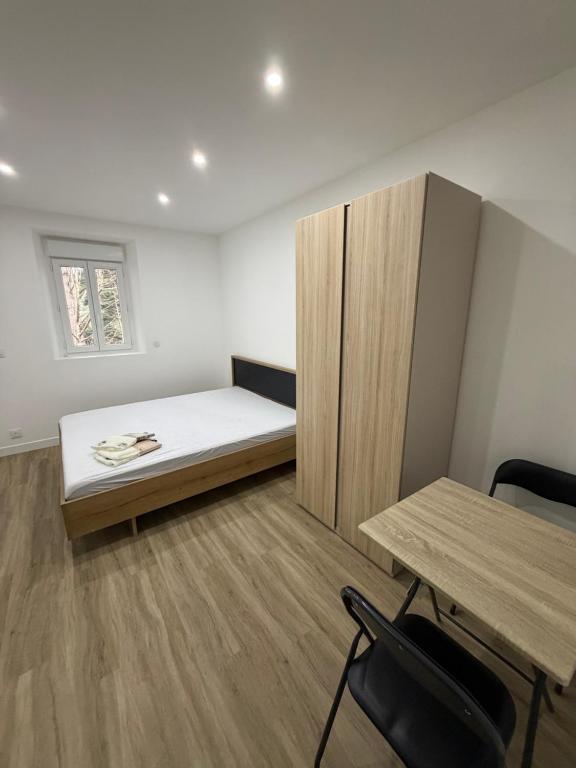 a room with a bed and a desk and a table at STUDIO deux NEUF A CROSNE in Crosne