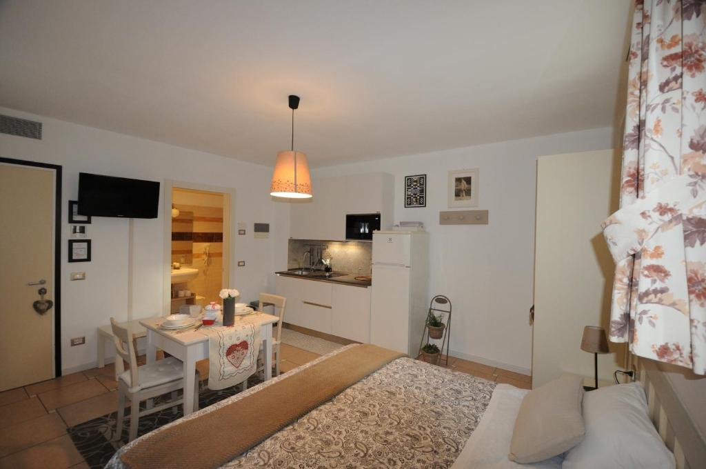 a living room with a kitchen and a table and a dining room at Casa Novecento "Rooms & apartments" in Feltre