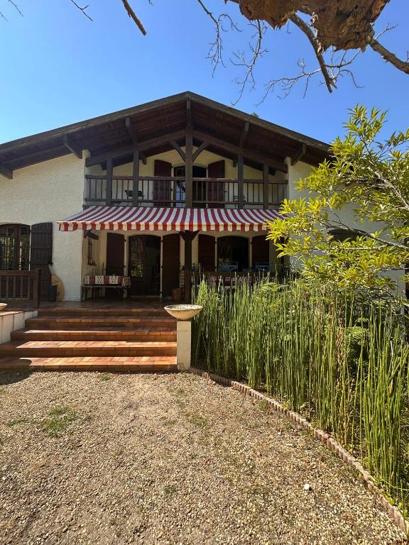 a house with a red and white striped awning at Yacumama Guesthouse in Soorts-Hossegor