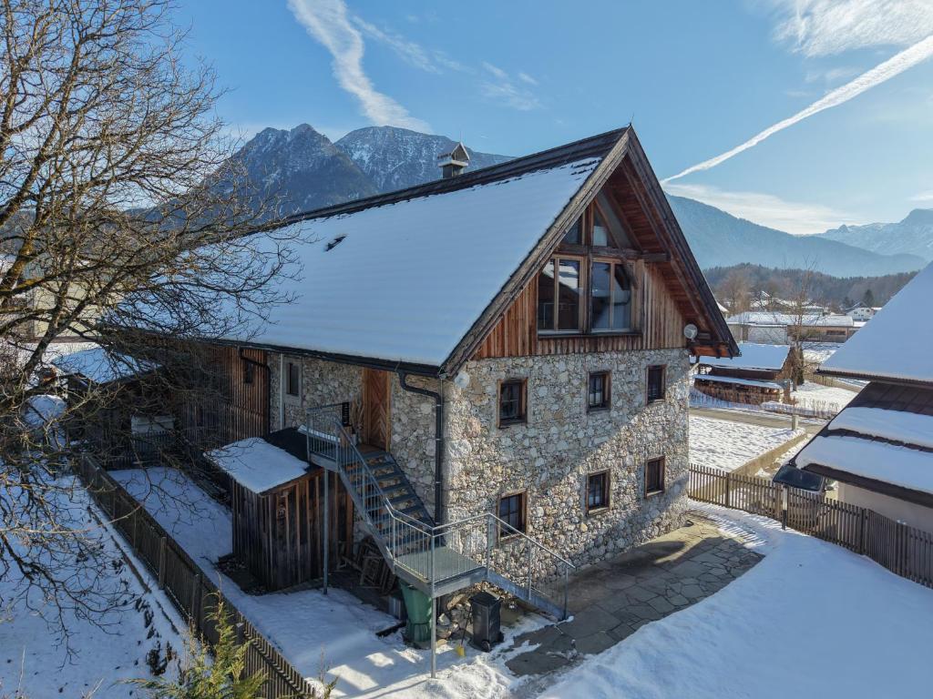a stone house with snow on the ground at Traunreiter Apartment in Bad Goisern