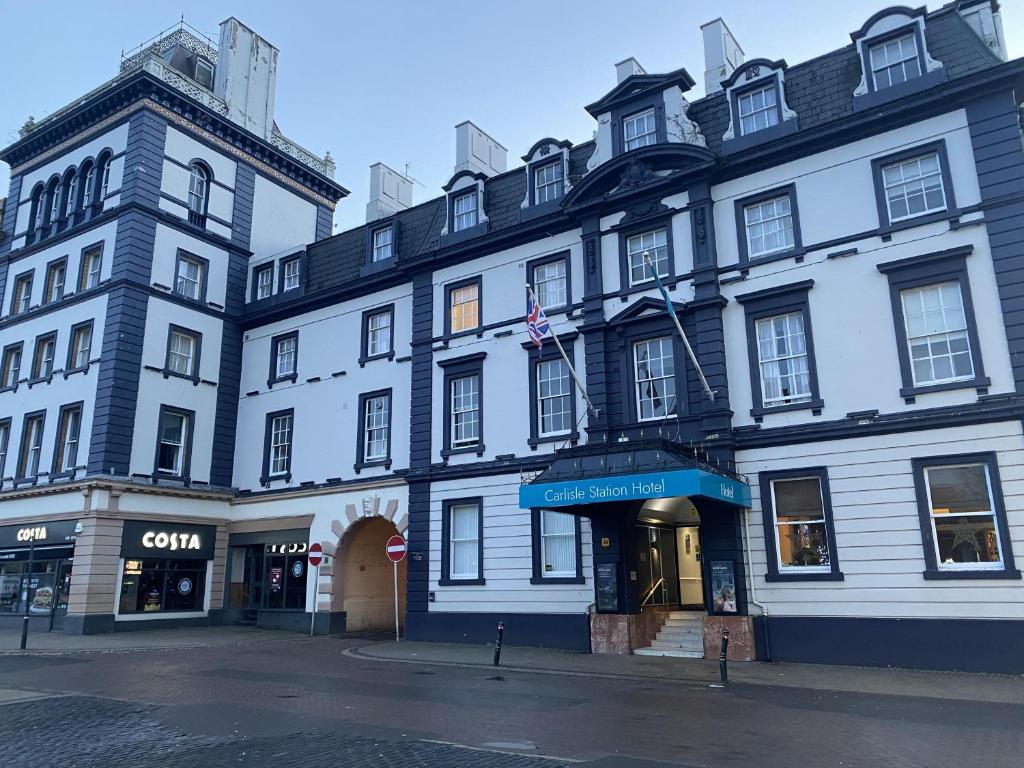 a large white building on the corner of a street at Carlisle Station Hotel, Sure Hotel Collection by BW in Carlisle