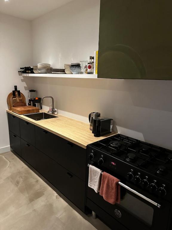 a kitchen with a black stove and a sink at Maastricht House Anne in Maastricht
