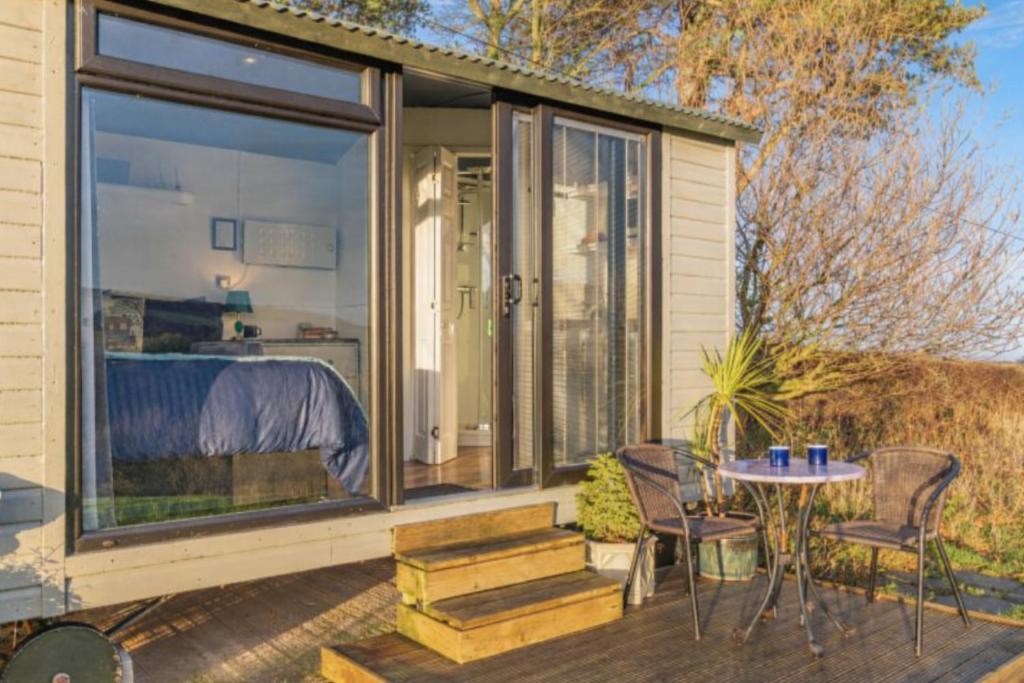 a screened in porch with a table and chairs at Shepherds Hut in Staithes