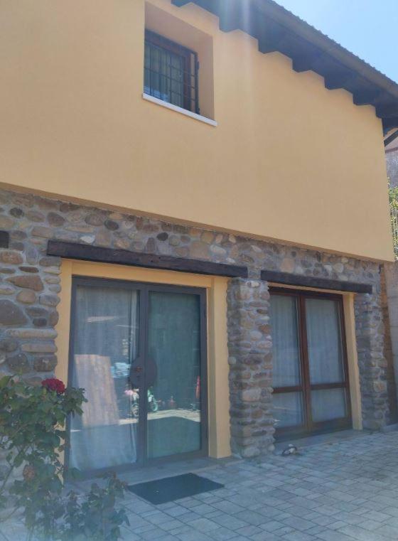 a building with two windows and a brick wall at B&B Occhio di Adone in Monzuno