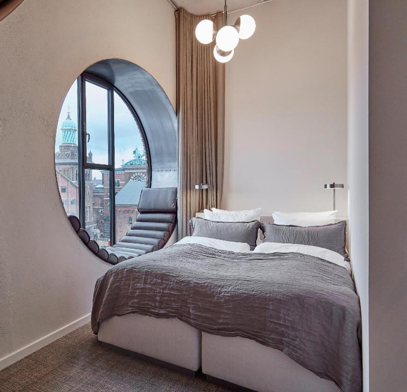 a bedroom with a large bed and a mirror at Boutique Hotel Ottilia in Copenhagen