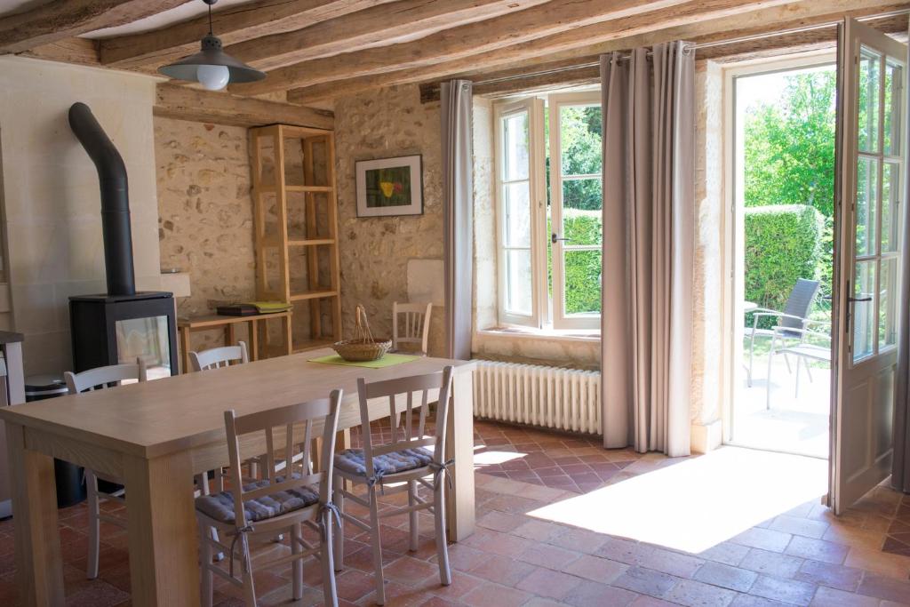 a kitchen with a table and chairs and a large window at L'Abeille bleue in Cheillé