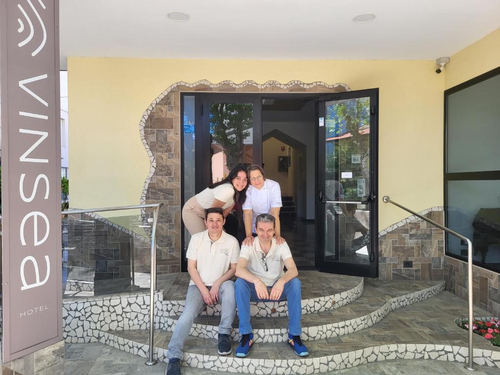 a group of people sitting on the steps of a house at Vinsea Hotel in Bellaria-Igea Marina