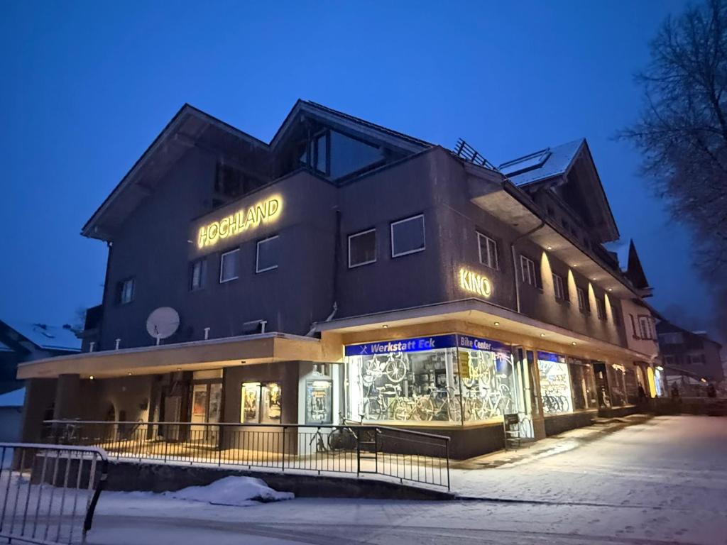 a building with a store in front of it at night at DAS LUDWIG - Haus HOCHLAND in Garmisch-Partenkirchen