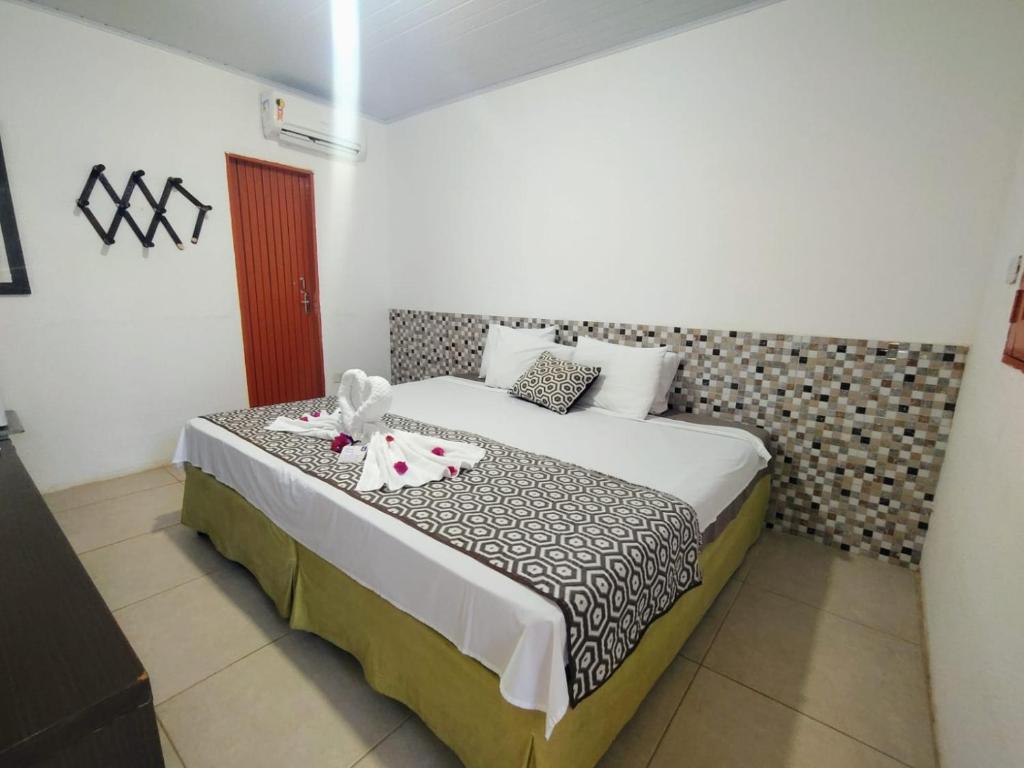 a bedroom with a large bed with flowers on it at POUSADA LUATOUR Praia Pontal do Coruripe in Coruripe
