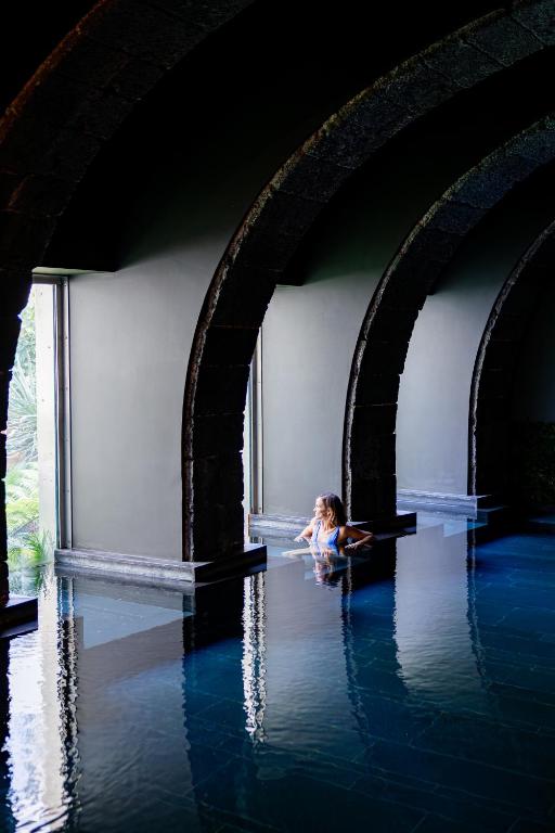 a little girl sitting in the water under a bridge at NINE DOTS Azorean Art Boutique Hotel in Ponta Delgada