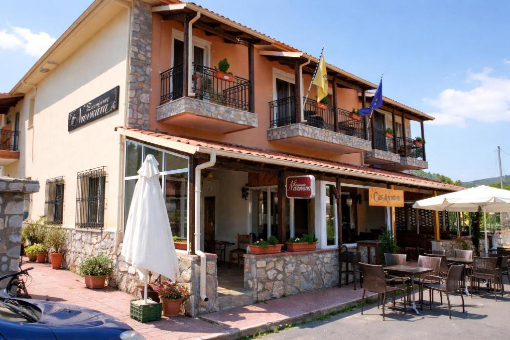 a building with an umbrella and a table and chairs at Ducata Hotel - Xirolivado in Xirolívadon