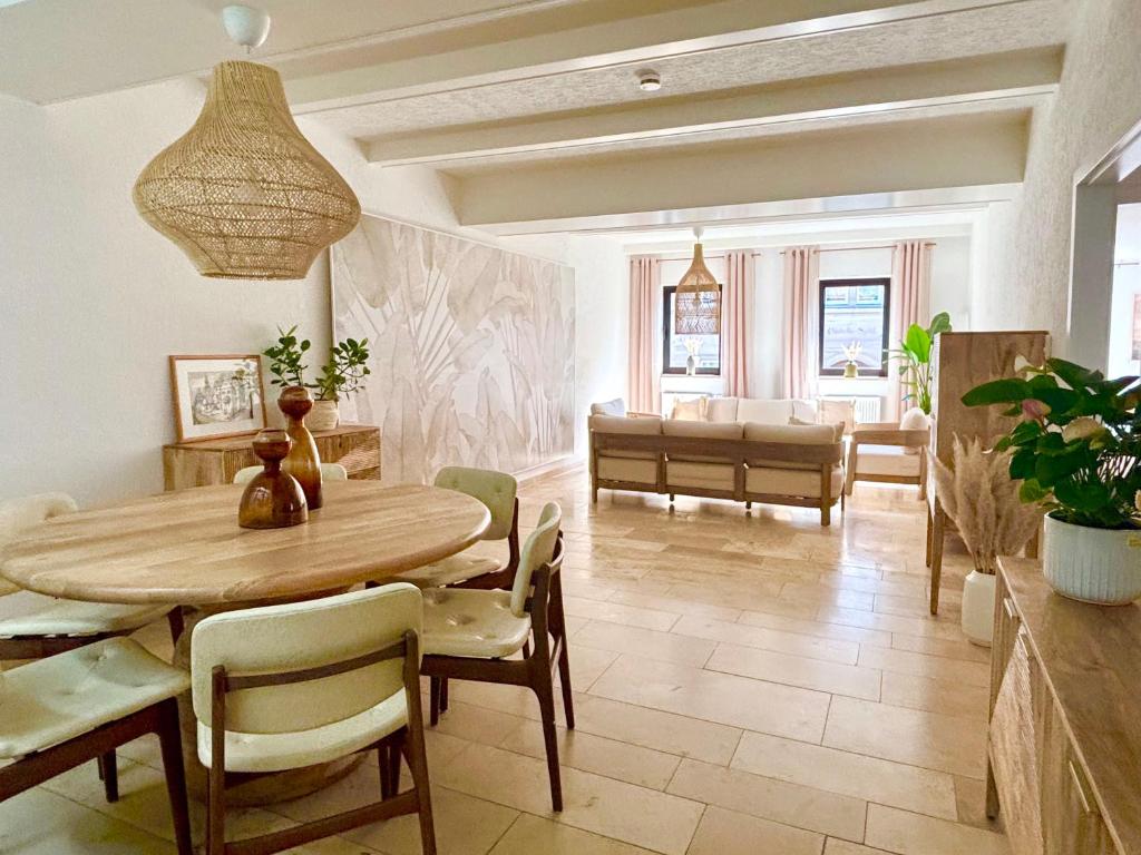 a dining room with a table and a living room at Ferienwohnung La Bohème in Bad Königshofen im Grabfeld