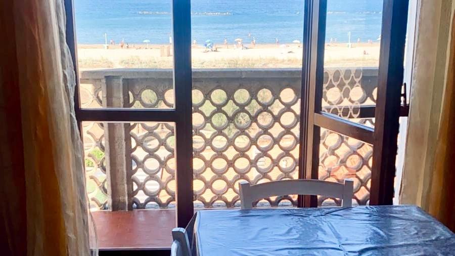 a table and chair on a balcony with a view of the beach at RM05 - Senigallia, trilocale fronte mare in Senigallia