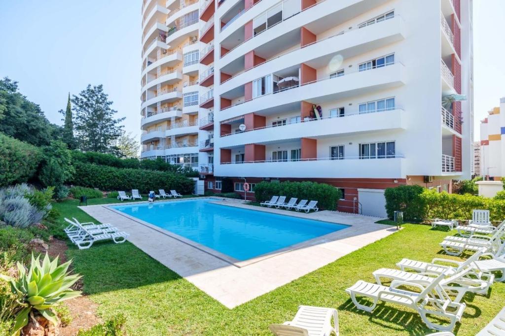 an apartment with a swimming pool and a building at Aqua Studio in Portimão