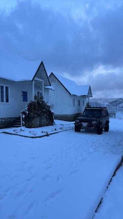 a truck parked in front of a house in the snow at Koçeku Brothers Guest House in Fushë-Lurë