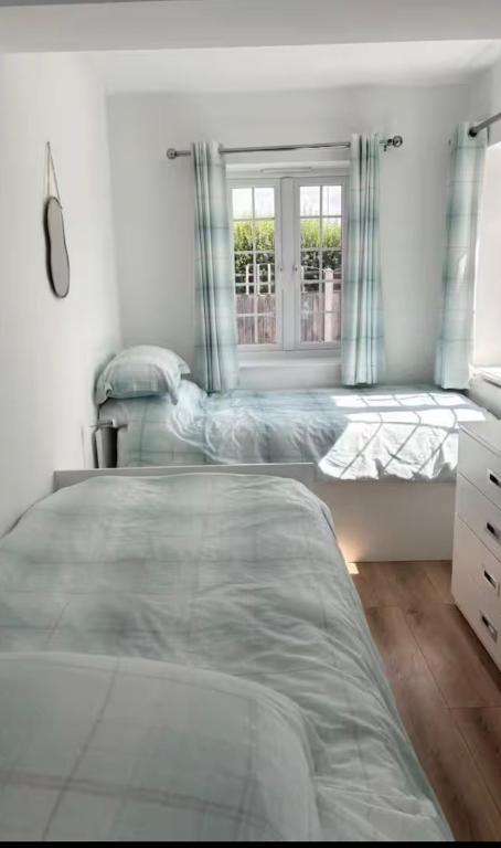 a bedroom with two beds and a window at Coach house in Enderby