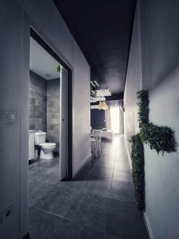 a bathroom with a toilet and a plant on the wall at Cozy Room G10 in Valencia