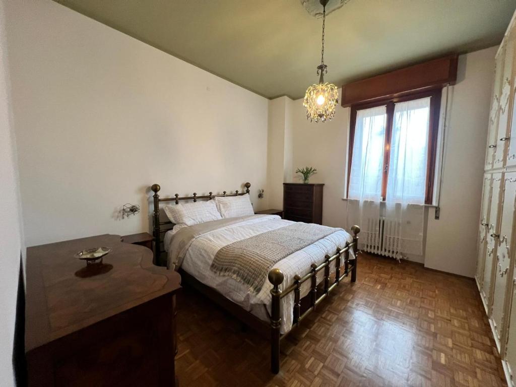 a bedroom with a bed and a table and a window at Da Carmela Italian Home in Mantova