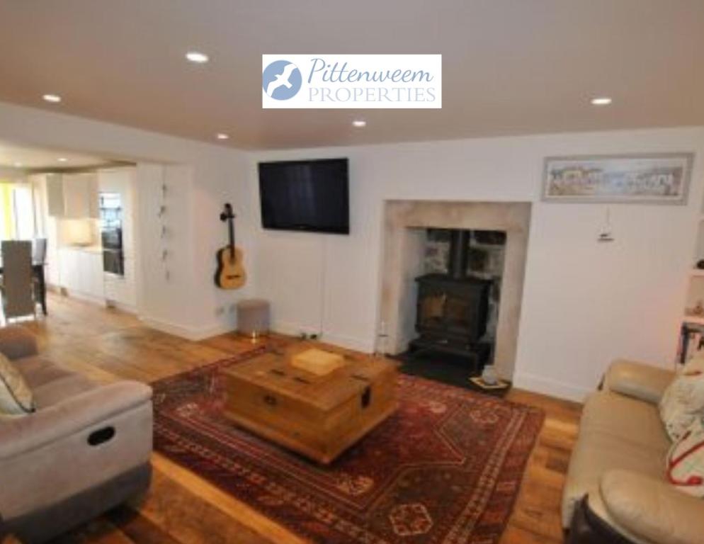 a living room with a couch and a coffee table at Aqua Vista- seafront cottage Cellardyke in Anstruther