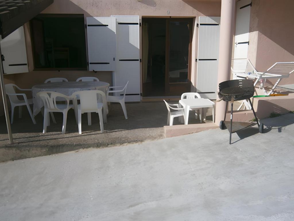 a patio with a table and chairs and a grill at T3 Mimizan Plage in Mimizan-Plage
