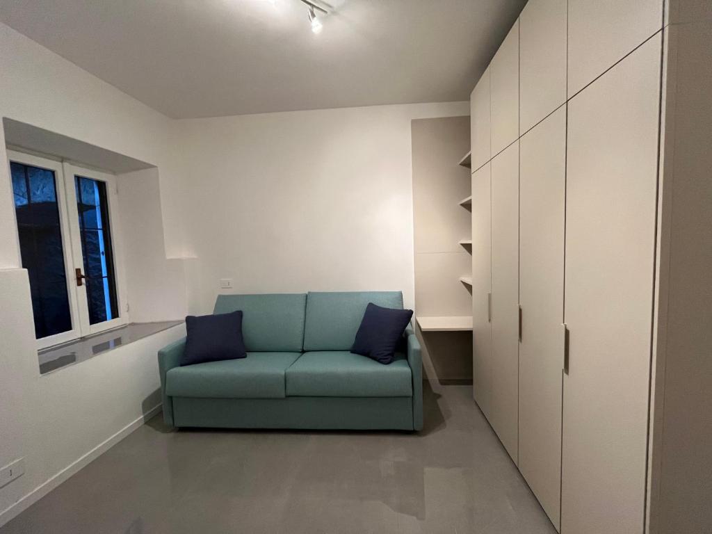 a living room with a blue couch and a window at Oasi di pace in Domaso