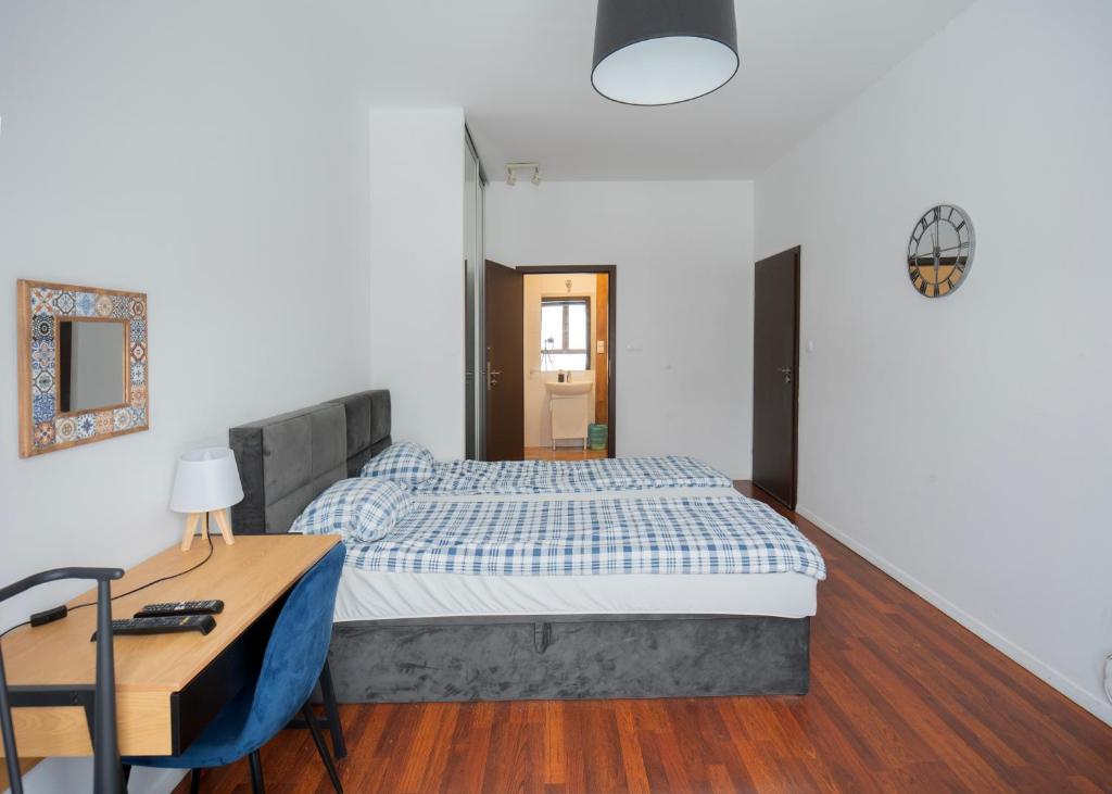 a bedroom with a bed and a desk in it at Rooms Green Rydygiera 17 own private room tv wifi in Warsaw
