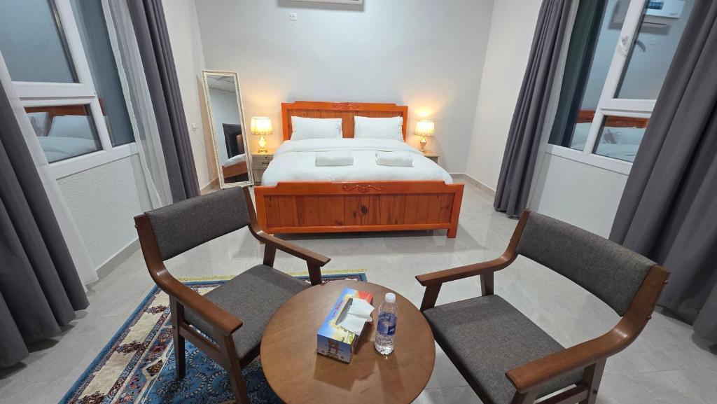 a bedroom with a bed and a table and chairs at Suhail Star Guest House in Misfāh
