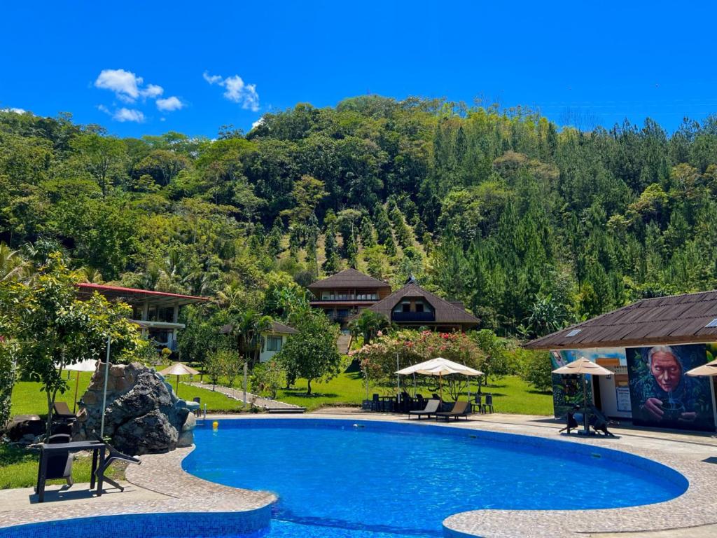 a pool at a resort with a mountain in the background at Mercedes Lodge in San Ramón