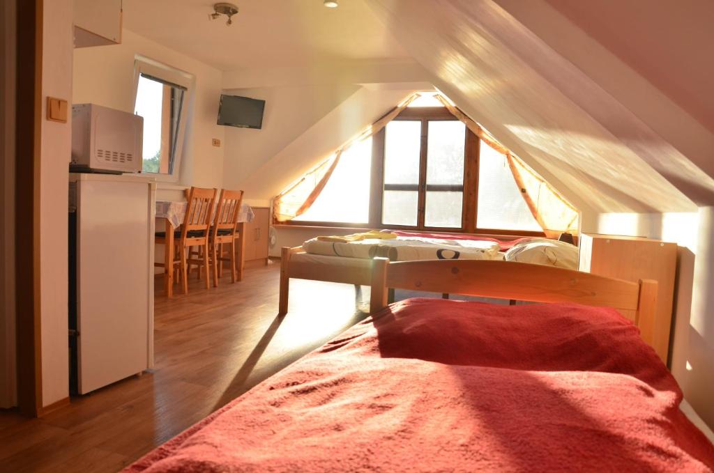 a room with a bed and a kitchen with a window at ubytování MILUMI in Strážnice