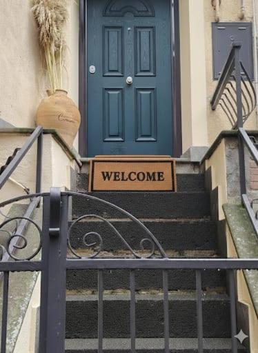 a blue door with a welcome sign in front at La Dimora Dei Cimini in Caprarola