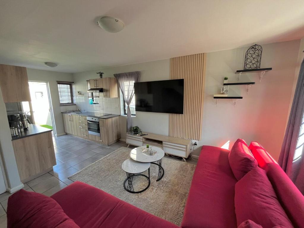 a living room with a red couch and a table at Valley Escape in Cape Town