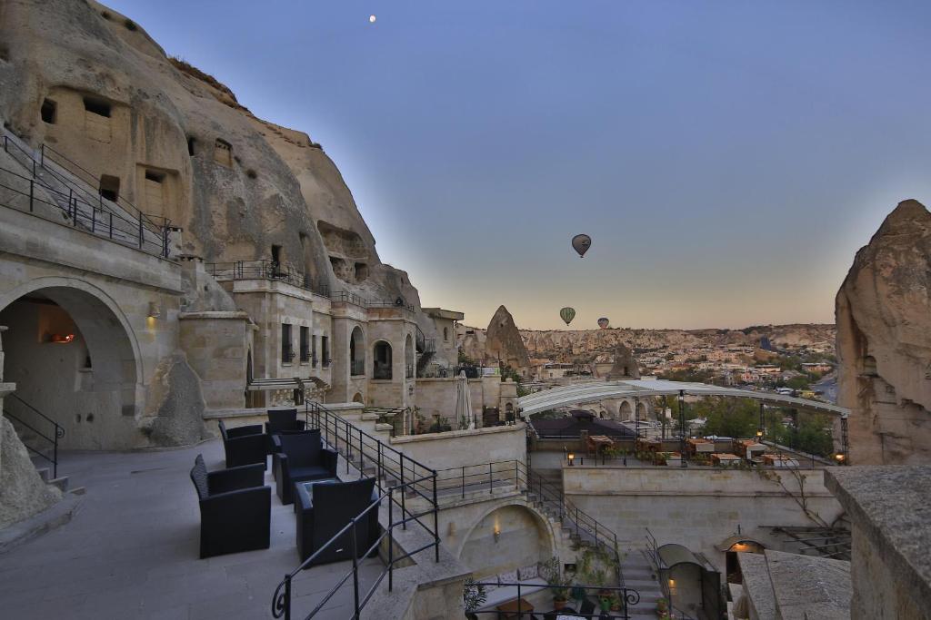 a balcony with chairs and a view of a city at Vezir Cave Suites in Göreme