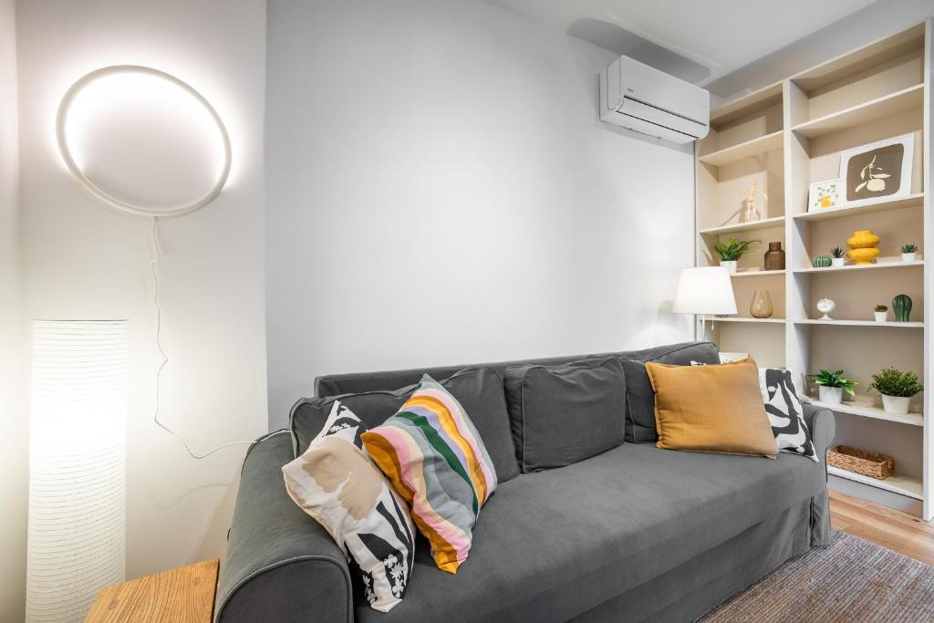 a living room with a gray couch with pillows at Vila Dolná in Banská Bystrica