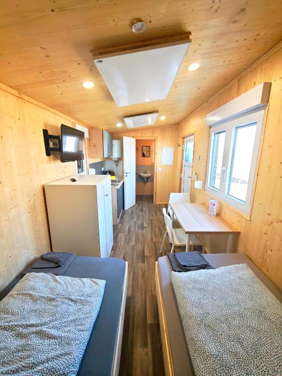 a room with two beds and a table and a kitchen at Tiny Guesthouse Euerbach in Euerbach