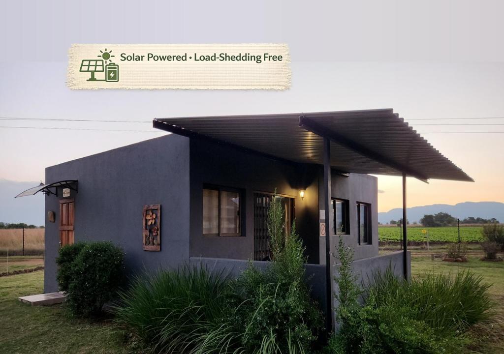 a small house with a black roof at Sunshine Cottage in Brits