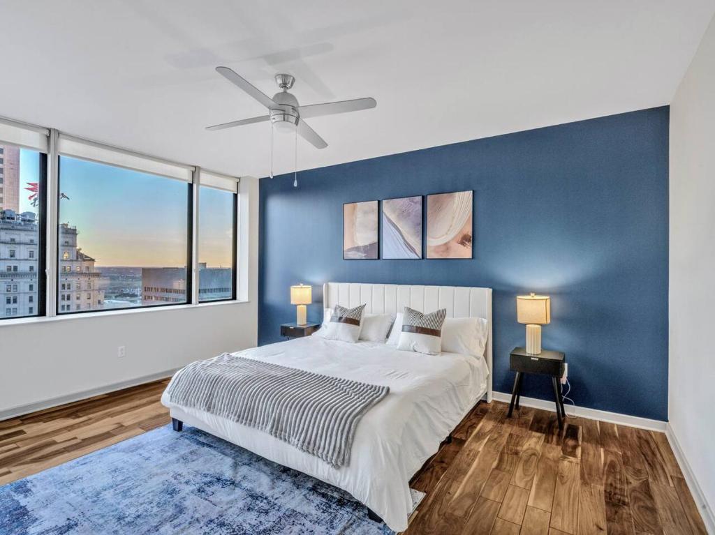 a bedroom with a large bed with a blue wall at Luxury Apt W/Parking CityView|Pool| Gym|PoolTable in Dallas