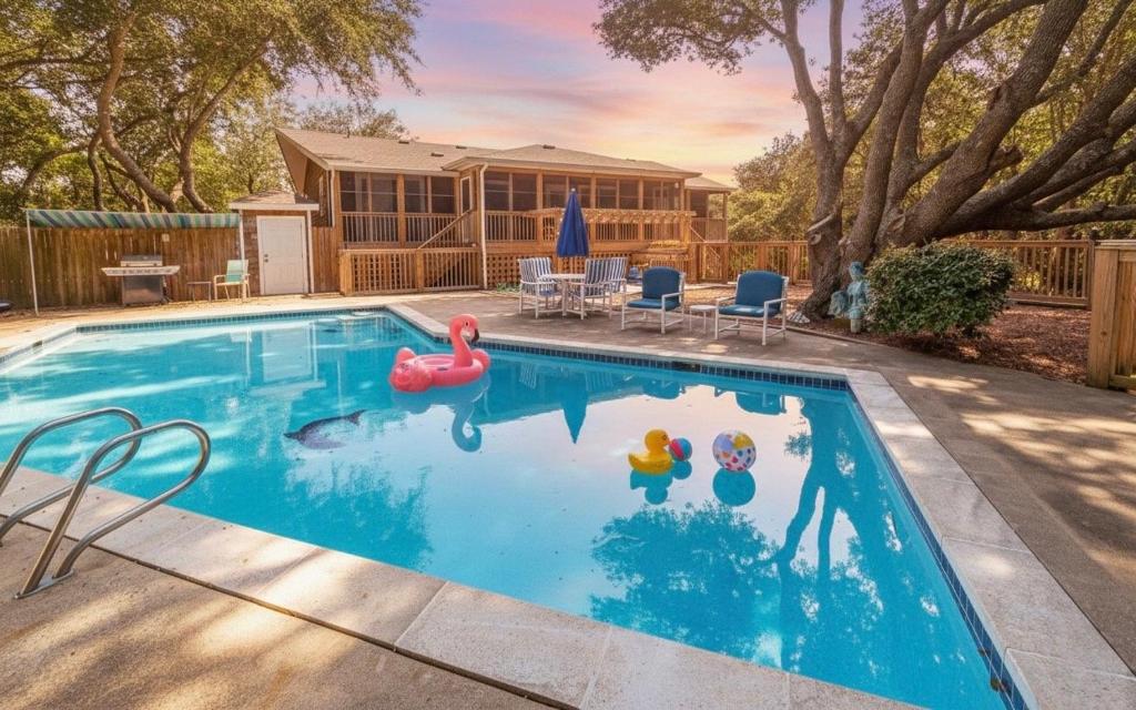 a swimming pool with two inflatables in a yard at Seascape Cottage - Kitty Hawk, MP 3.5, 300 Yds to Beach, Pool, Foosball, Near Golf Course, Flex Stays in Kitty Hawk