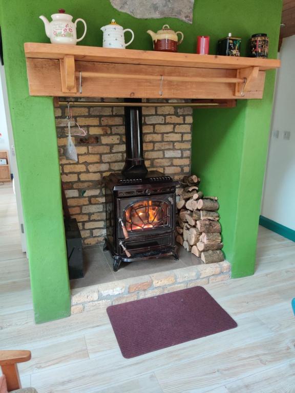 a brick fireplace with a stove in a room at Carrowkeel Cottage in Athlone