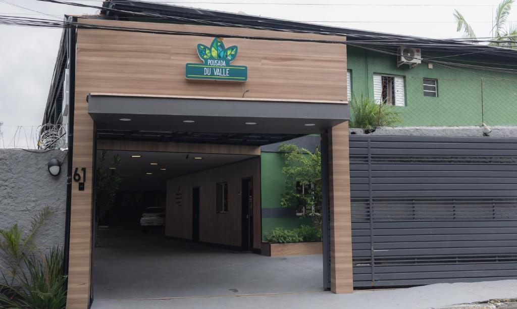 a building with a garage with a sign on it at Pousada Du Valle in Embu