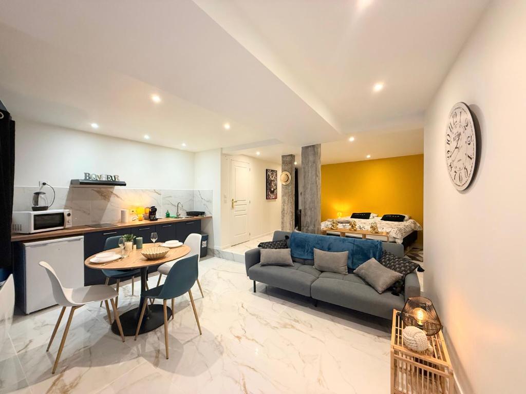 a living room with a couch and a table at Magnifique studio, proche du centre in Rodez