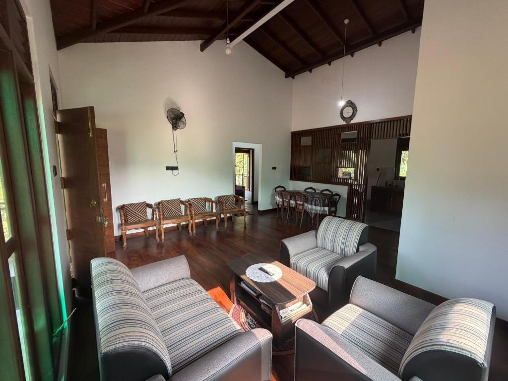 a living room with couches and a dining room at Gurugoda Riverside Villa in Ruwanwella